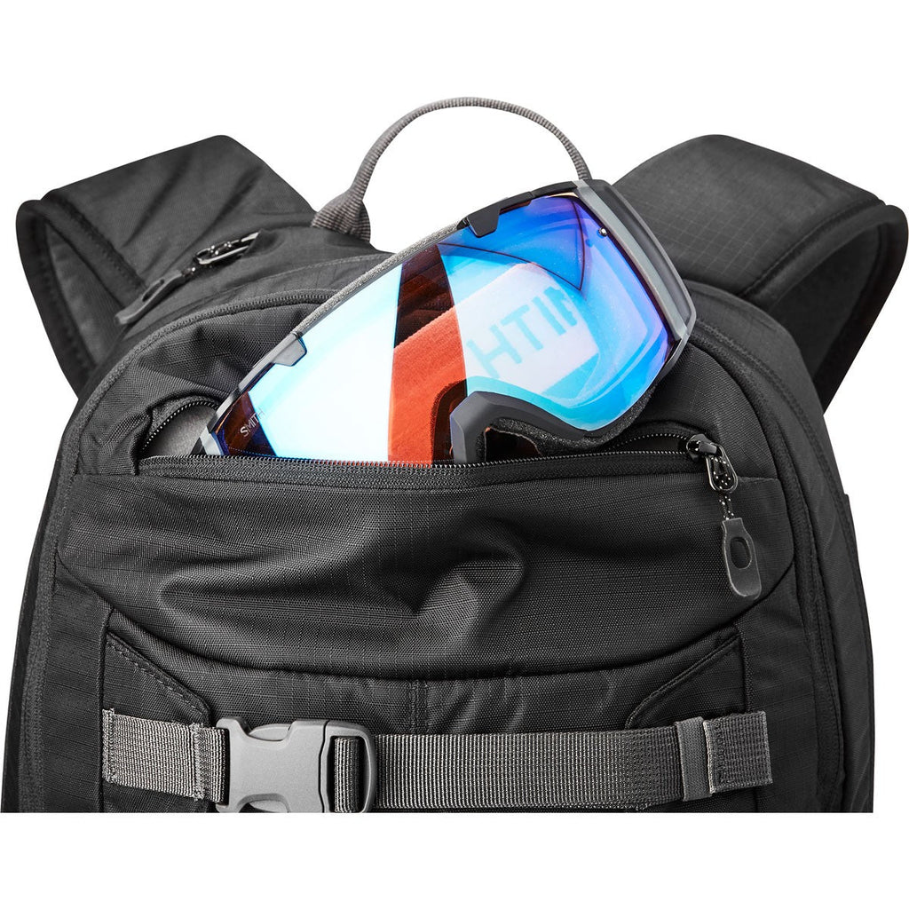 Dakine Mission Pro Snowboard backpack in all black. Photo shows the top goggle pocket. Size: 18 liters.